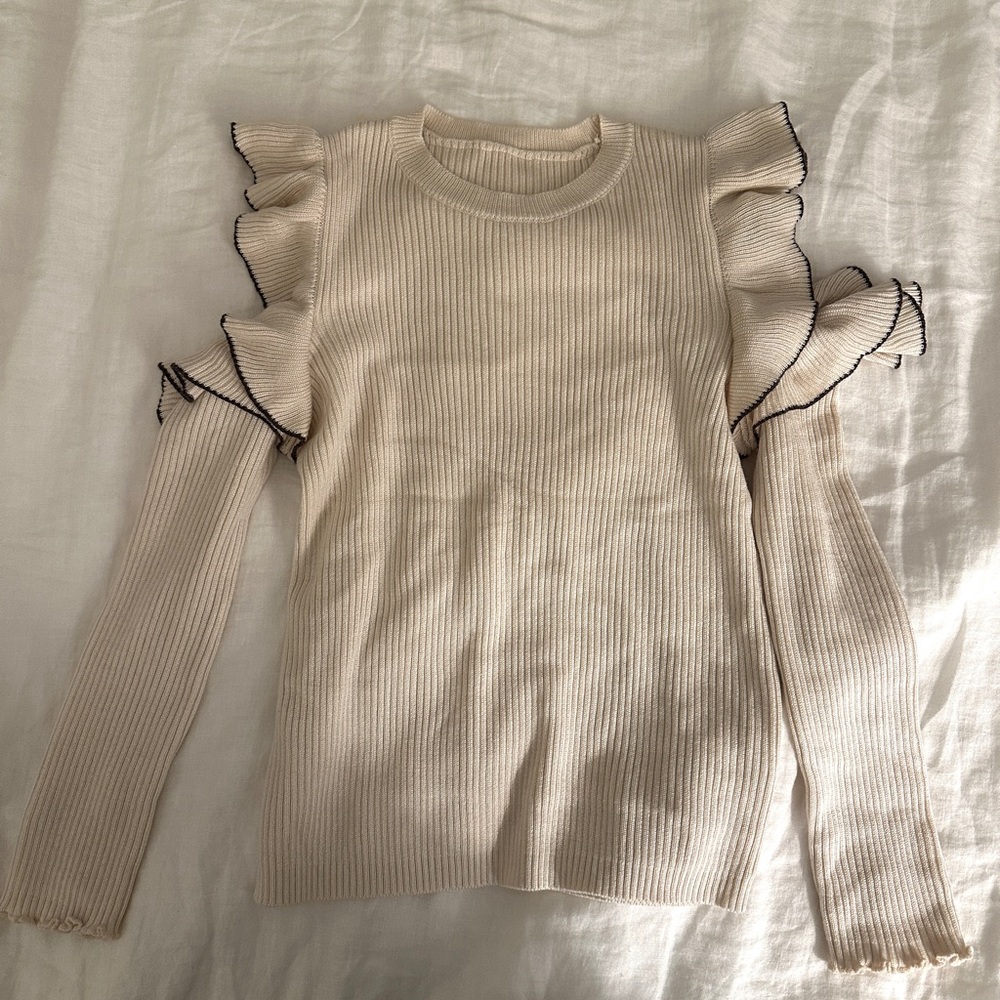 Cream ruffle knit shoulder cut out sweater with brown trim